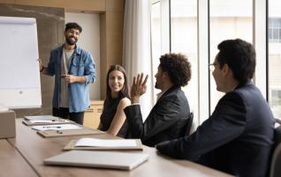 Teilnehmende eines offenen Seminars im Gespräch mit dem Dozenten am Flipchart