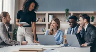 Personalreferentin steht vor ihrem Team und moderiert eine Besprechung im Büro